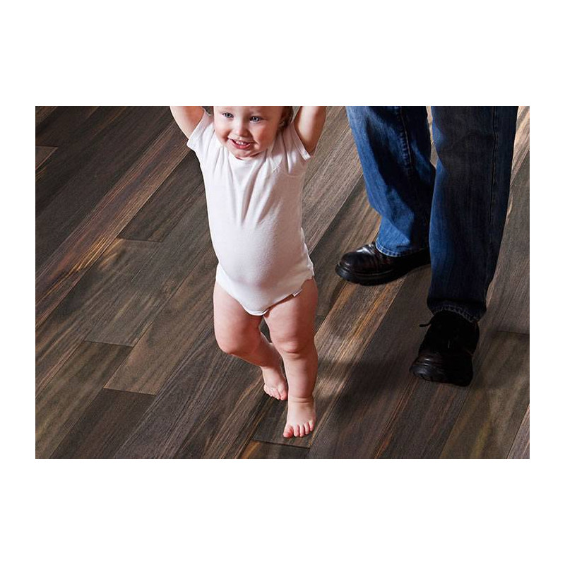 Un enfant s\'amuse en marchant, aidé par un adulte, sur un beau parquet qui invite aux moments de complicité en famille.