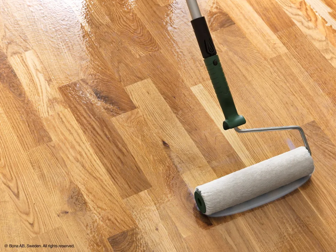application vitrificateur Bona au rouleau sur parquet chêne