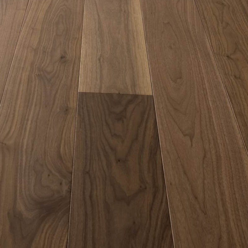 Parquet noyer design — vue produit lames massif noyer européen teinte naturelle brun doré, pose clouée sur lambourdes, rendu haut de gamme