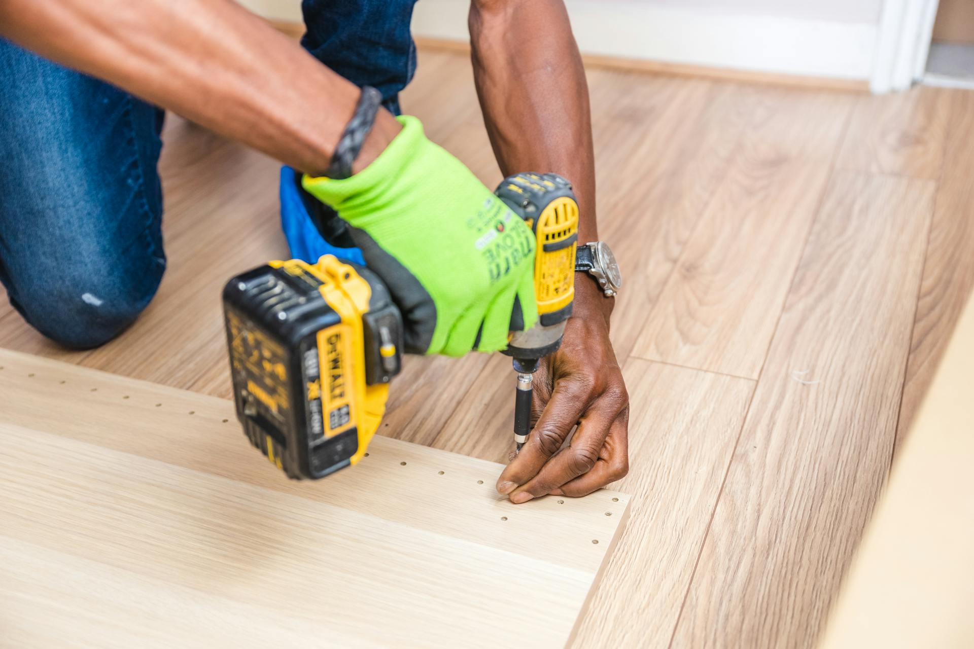 Parqueteur professionnel réalisant une pose de parquet en bois massif — détail finition